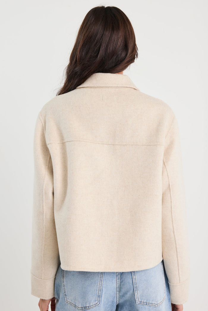 Person wearing a beige jacket and blue jeans on a white background
col_pattern