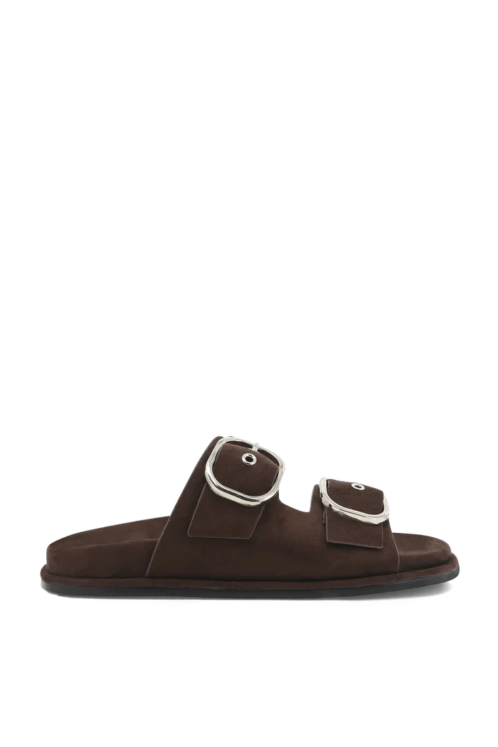 A single dark brown suede slide sandal with two adjustable straps and large silver-tone metal buckles, shown in profile against a plain white background.