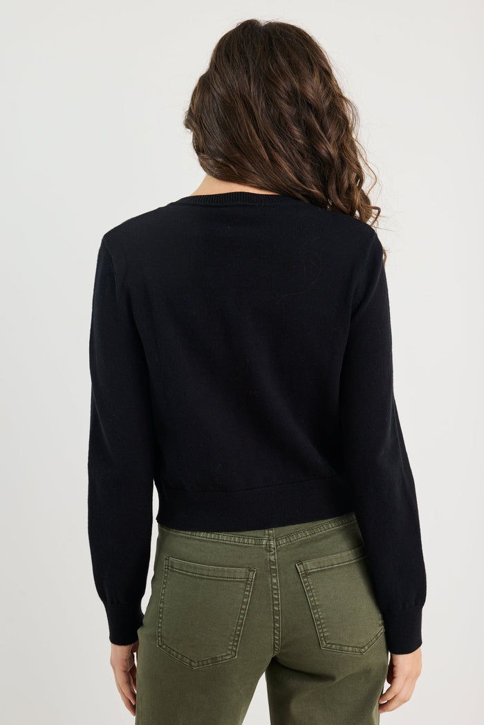 Person wearing a black sweater and green pants on a white background
@col_pattern