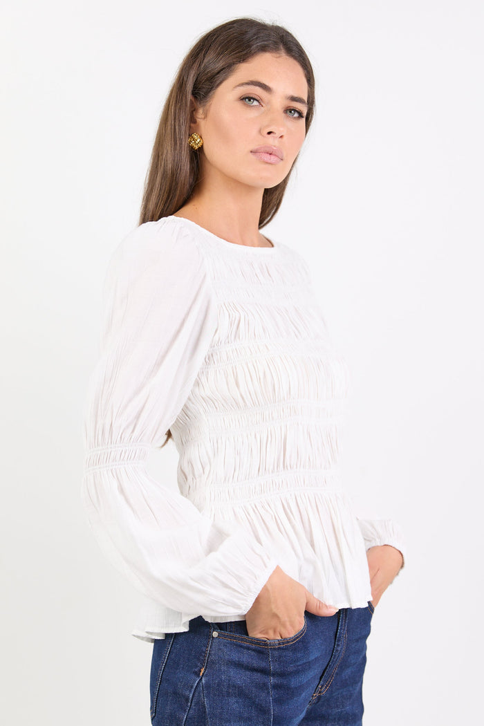 Woman wearing a white blouse and blue jeans on a white background