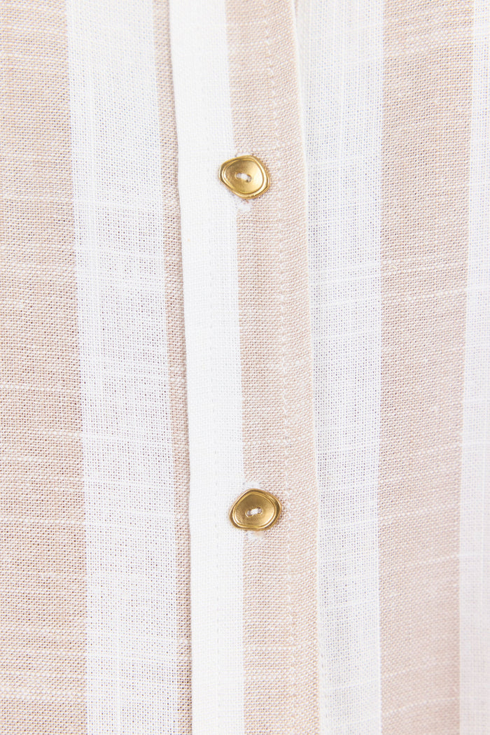 Close-up of a striped fabric with gold buttons on a white background