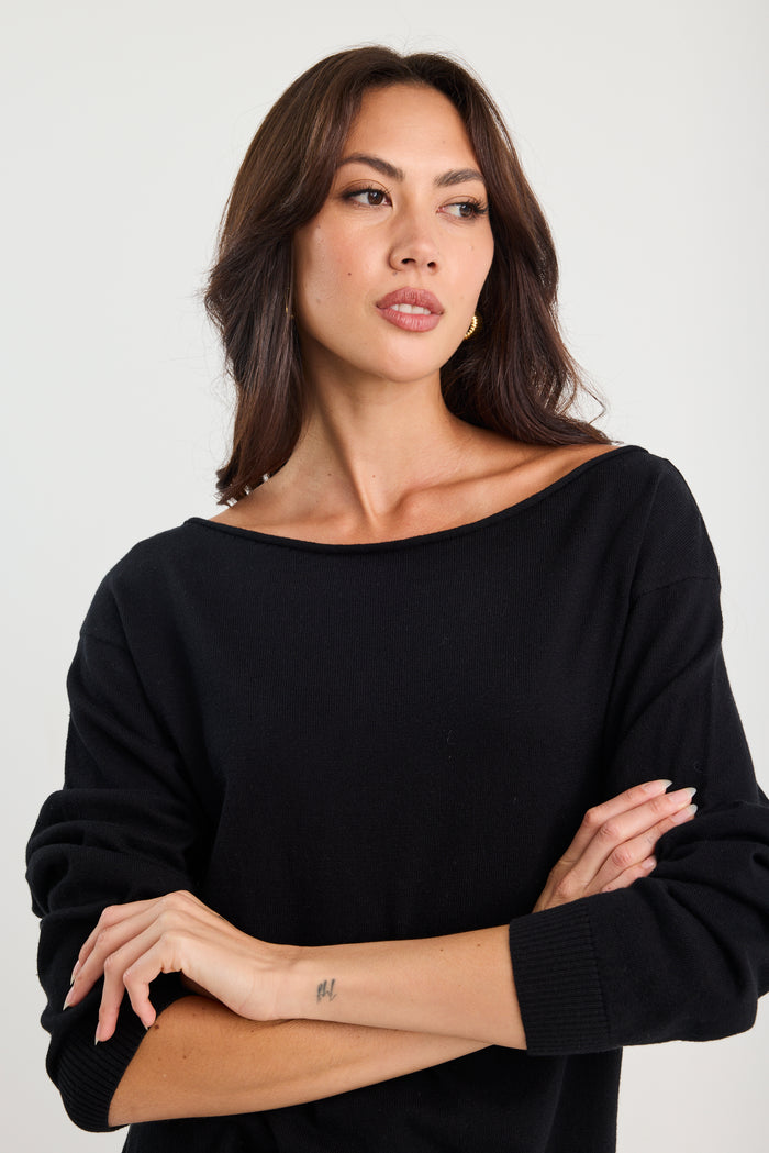 Woman wearing a black sweater against a white background