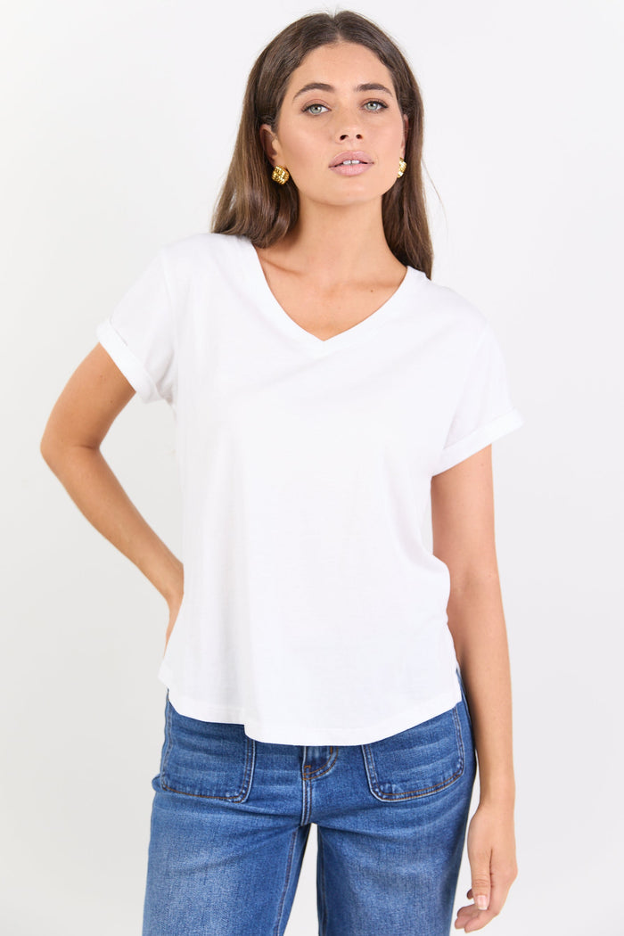 Woman wearing a white t-shirt and blue jeans on a white background