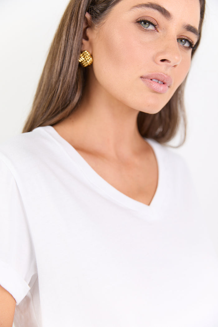 Woman wearing a white top with a plain background