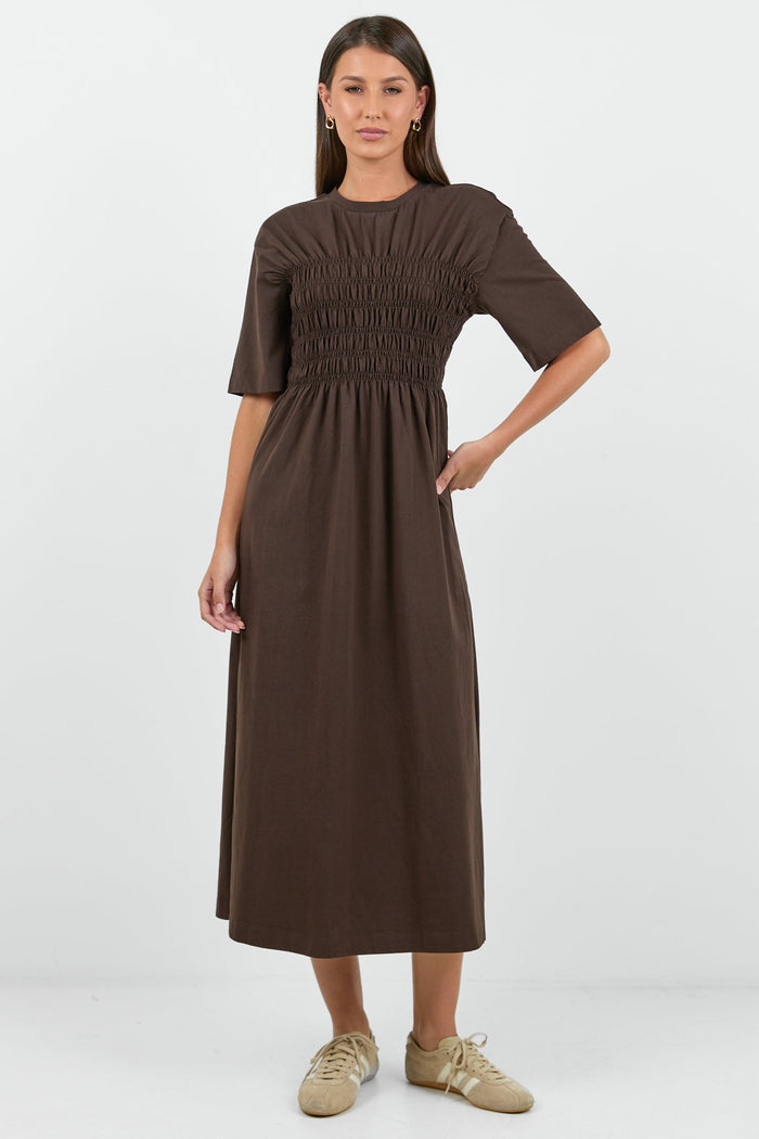 Woman wearing a brown dress on a white background