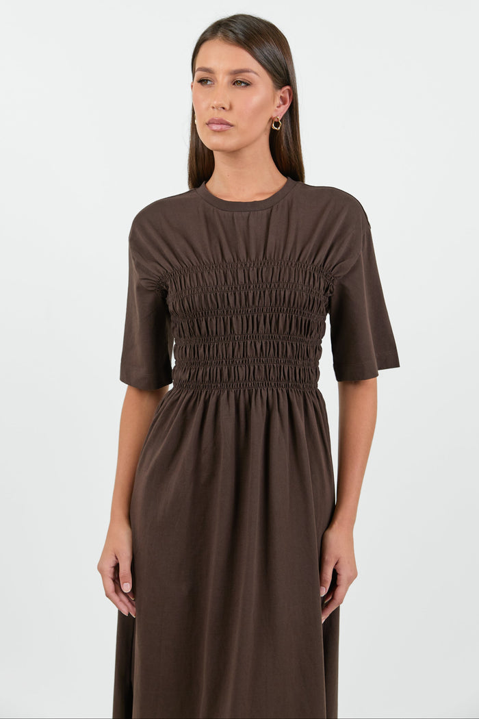 Woman wearing a brown dress against a white background
