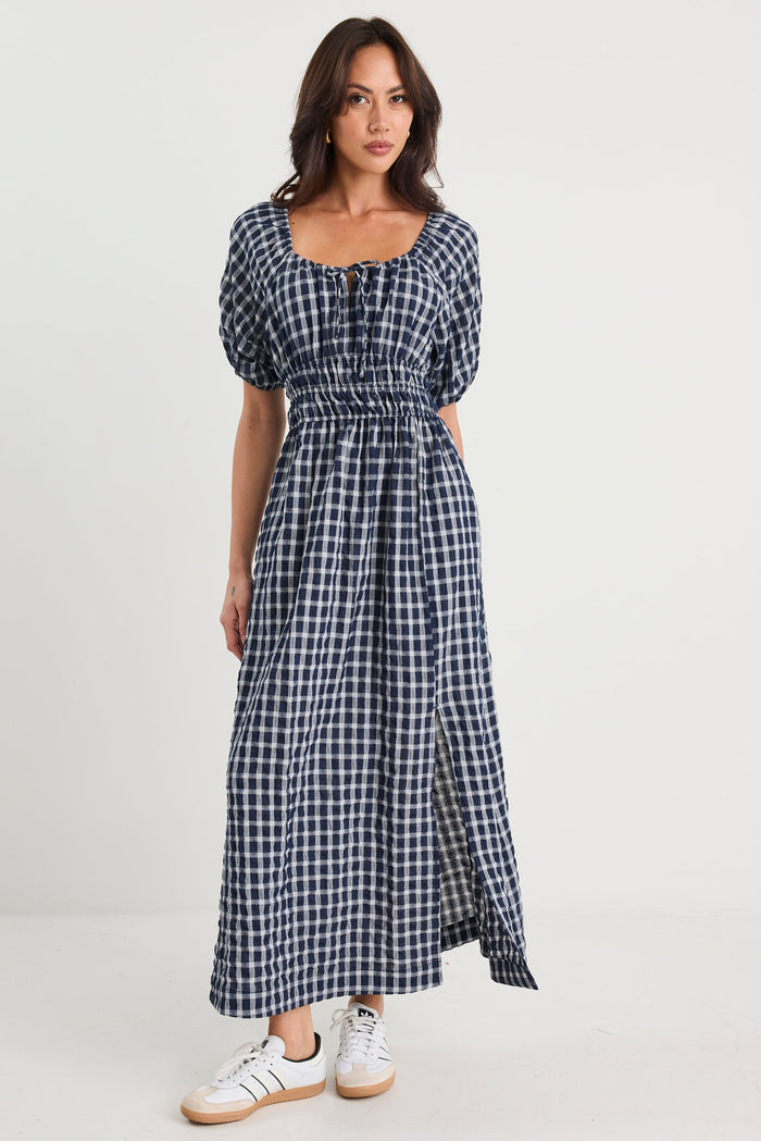Woman wearing a blue checkered dress on a white background