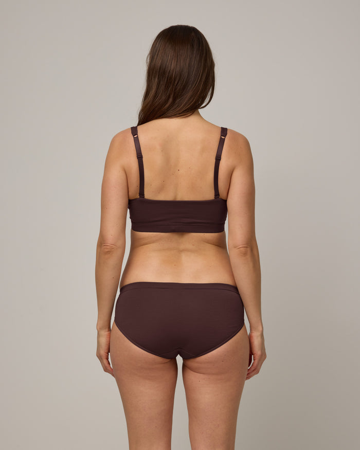 Model wearing Roam Bikini in Espresso, a dark brown color. Roam Bikini is a merino wool underwear available in sizes XS-3X.