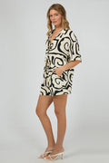high-waisted cream shorts with bold black swirl print, elastic waistband, and side pockets, styled with matching shirt