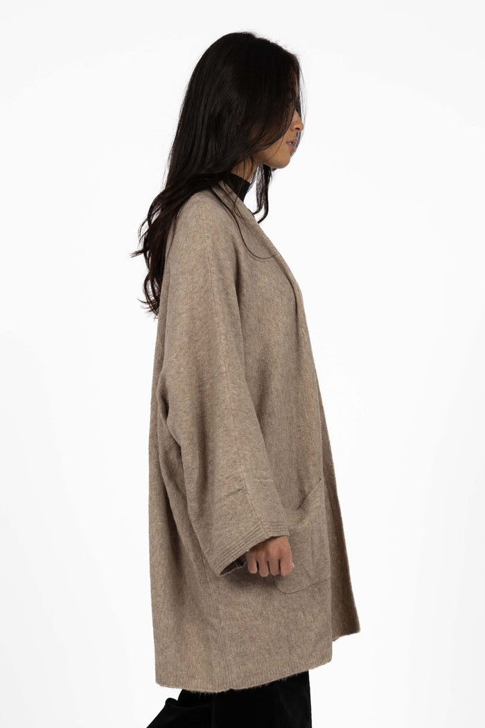 Woman wearing a beige coat and black pants on a white background
col_pattern