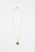 gold-plated necklace with fine chain and a round sunburst pendant featuring a central gem detail,