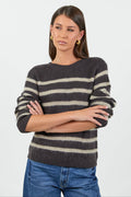 Woman wearing a striped sweater and jeans on a white background