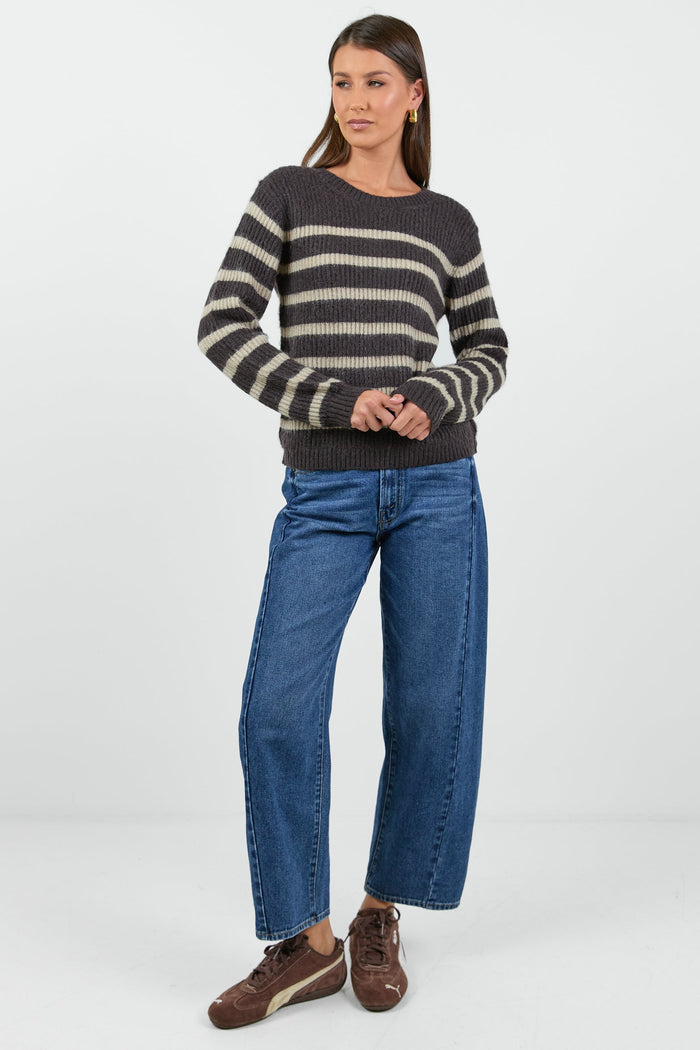 Woman wearing a striped sweater and jeans on a white background