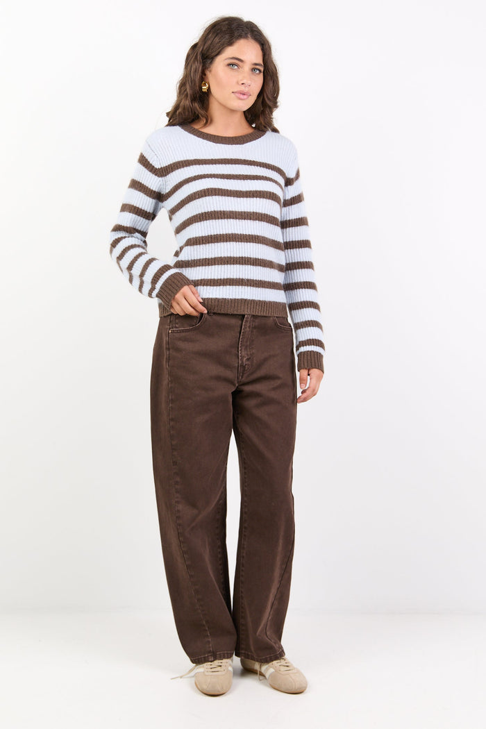 Person wearing a striped sweater and brown pants on a white background