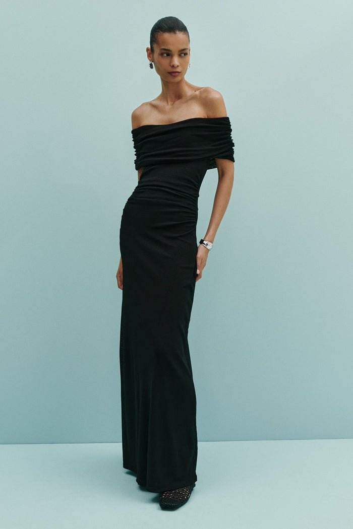 Woman wearing a black off-shoulder gown against a light blue background