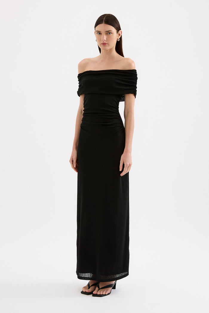 Woman wearing a black off-shoulder gown on a white background