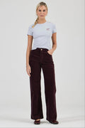 Woman wearing a light gray t-shirt and dark brown corduroy pants on a white background