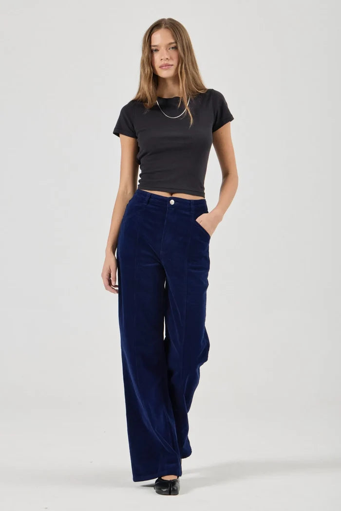 Woman wearing a black t-shirt and blue pants on a white background