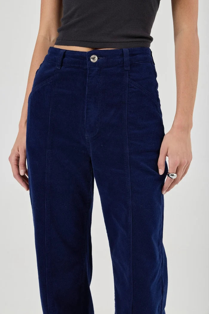 Navy blue corduroy pants worn by a person on a white background