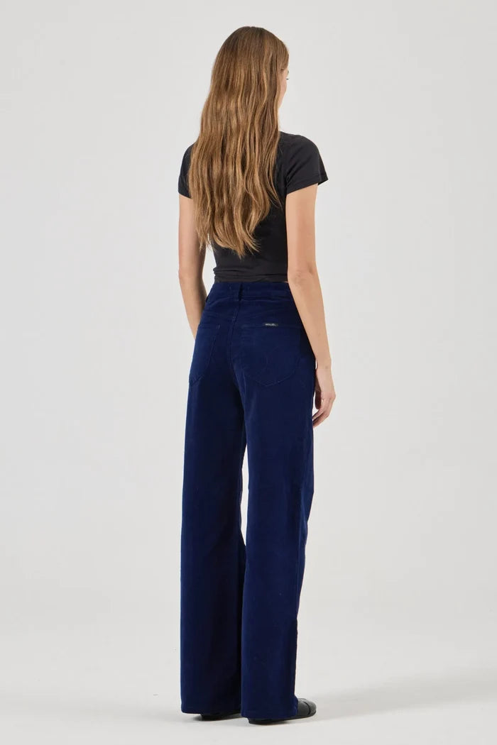 Person wearing navy blue pants and a black top on a white background