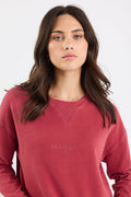Woman wearing a red sweatshirt with 'Re:union' text on a white background