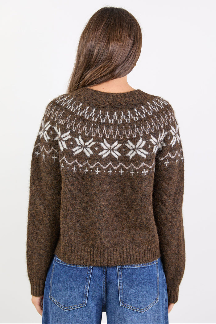Person wearing a brown sweater with a white pattern, standing against a white background
col_pattern