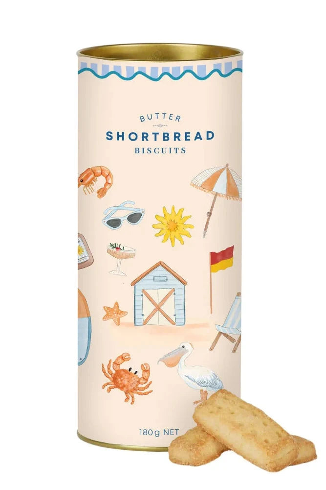 A cylindrical tin of Butter Shortbread Biscuits with a cream-colored label decorated with beach-themed illustrations, with two golden-brown biscuits placed in front on a white background.