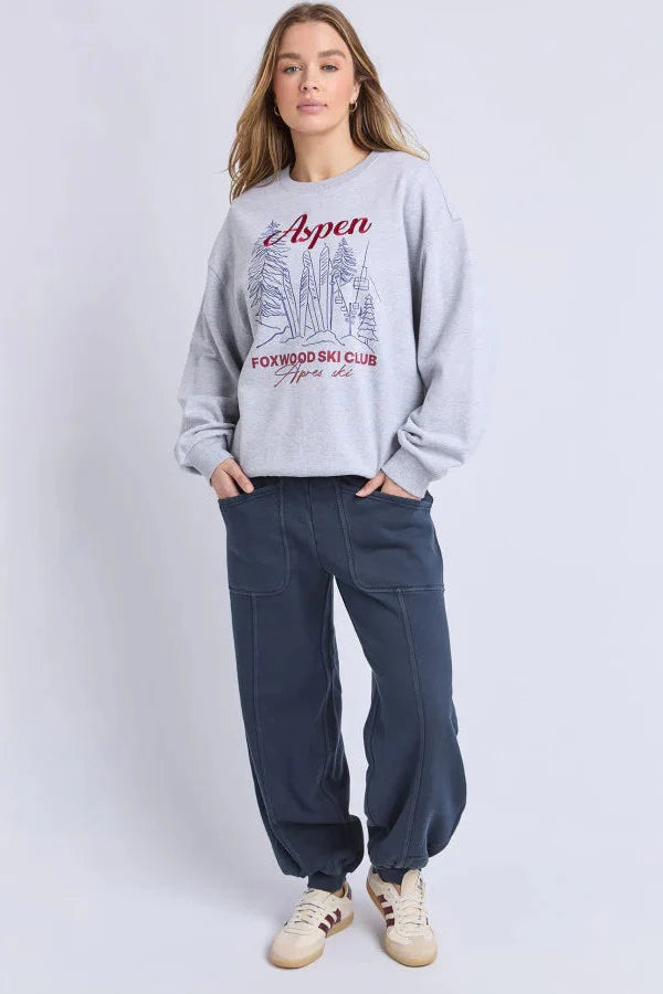 Woman wearing a gray sweatshirt with 'Aspen' and 'Foxwood Ski Club' text on a white background