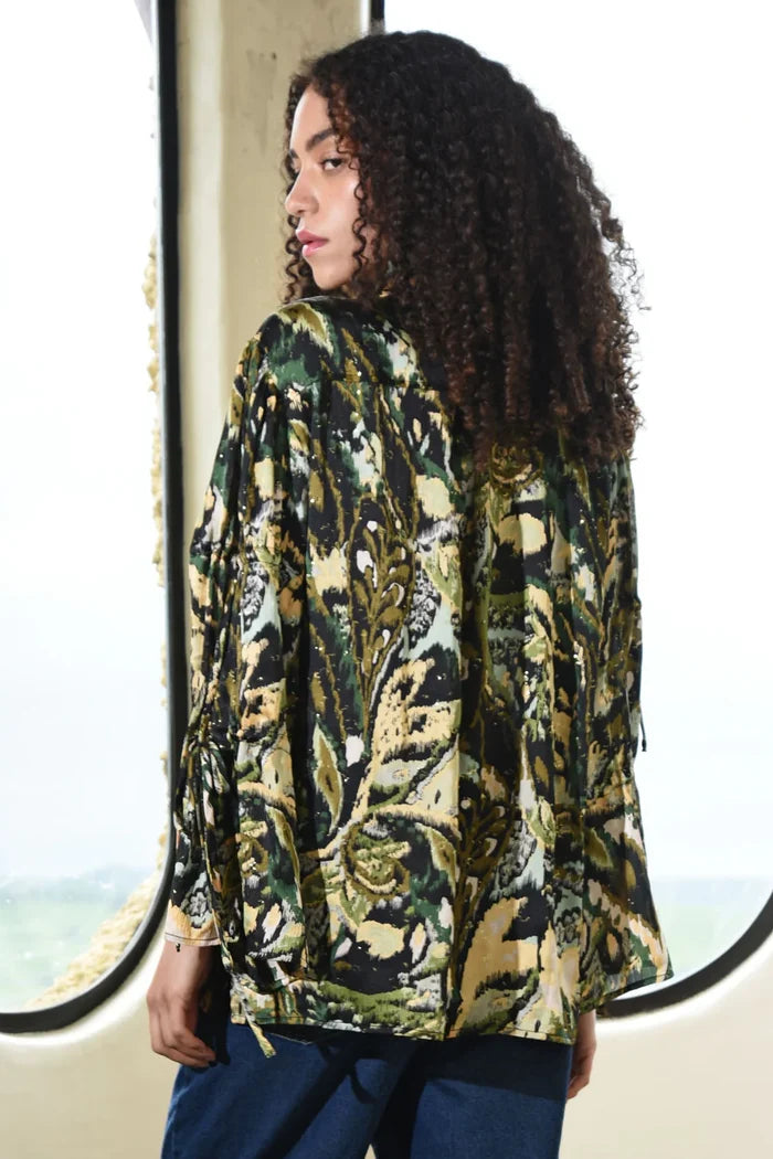 Woman wearing a patterned jacket standing in front of a window