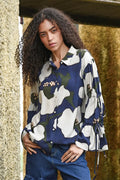 Woman wearing a floral patterned shirt with a blurred natural background