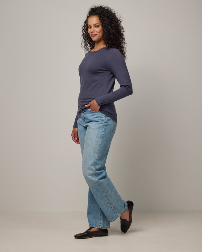 Model wearing Sloan 100% Fitted Tee in Odyssey Gray, a slate blue-gray color. Sloan 100% Fitted Tee is a merino wool long sleeve, crew neck, slim fit tee available in sizes XS-3X.