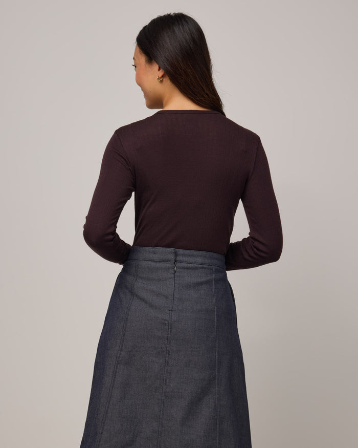 Model wearing Sloan Pointelle Fitted Tee in Espresso, a dark brown color. Sloan Pointelle Fitted Tee is a merino wool long sleeve, crew neck, slim fit tee available in sizes XS-3X.