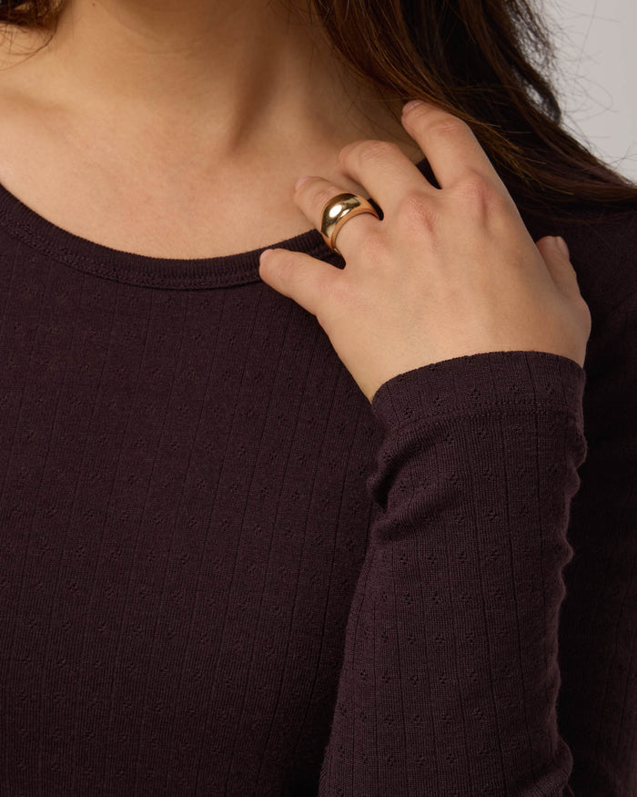 Model wearing Sloan Pointelle Fitted Tee in Espresso, a dark brown color. Sloan Pointelle Fitted Tee is a merino wool long sleeve, crew neck, slim fit tee available in sizes XS-3X.