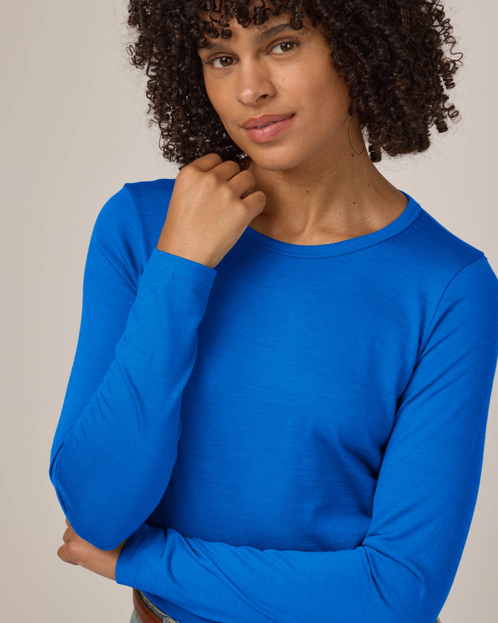 Model wearing Sloan Signature Fitted Tee in Ultramarine, a vibrant cobalt blue color. Sloan Signature Fitted Tee is a merino wool long sleeve, crew neck, slim fit tee available in sizes XS-3X.