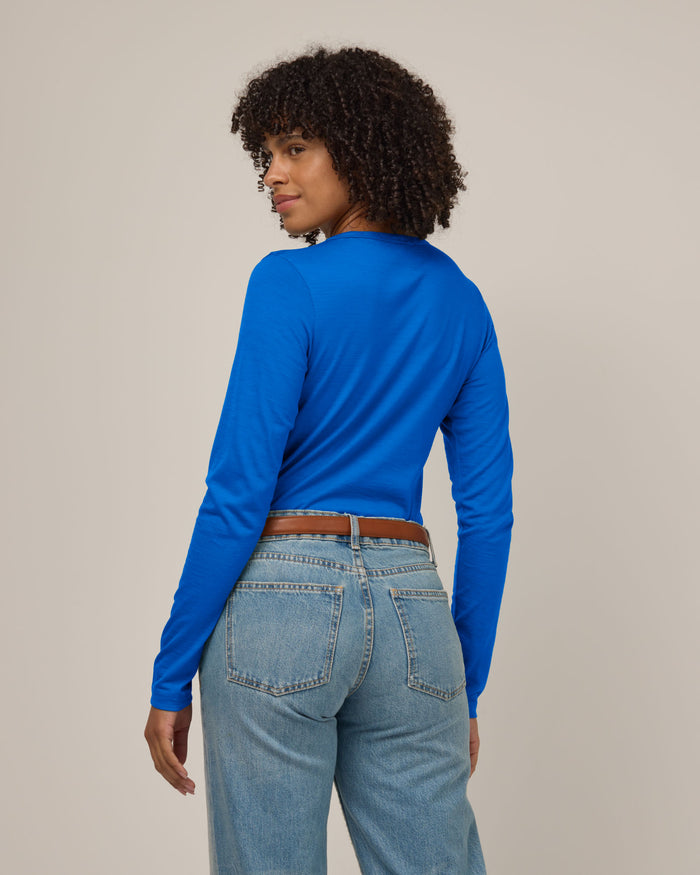 Model wearing Sloan Signature Fitted Tee in Ultramarine, a vibrant cobalt blue color. Sloan Signature Fitted Tee is a merino wool long sleeve, crew neck, slim fit tee available in sizes XS-3X.