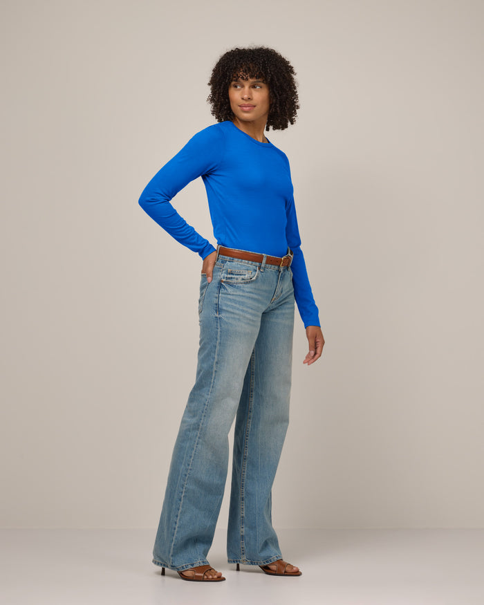 Model wearing Sloan Signature Fitted Tee in Ultramarine, a vibrant cobalt blue color. Sloan Signature Fitted Tee is a merino wool long sleeve, crew neck, slim fit tee available in sizes XS-3X.
