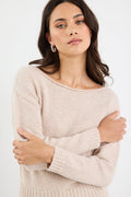 Woman wearing a beige sweater against a white background