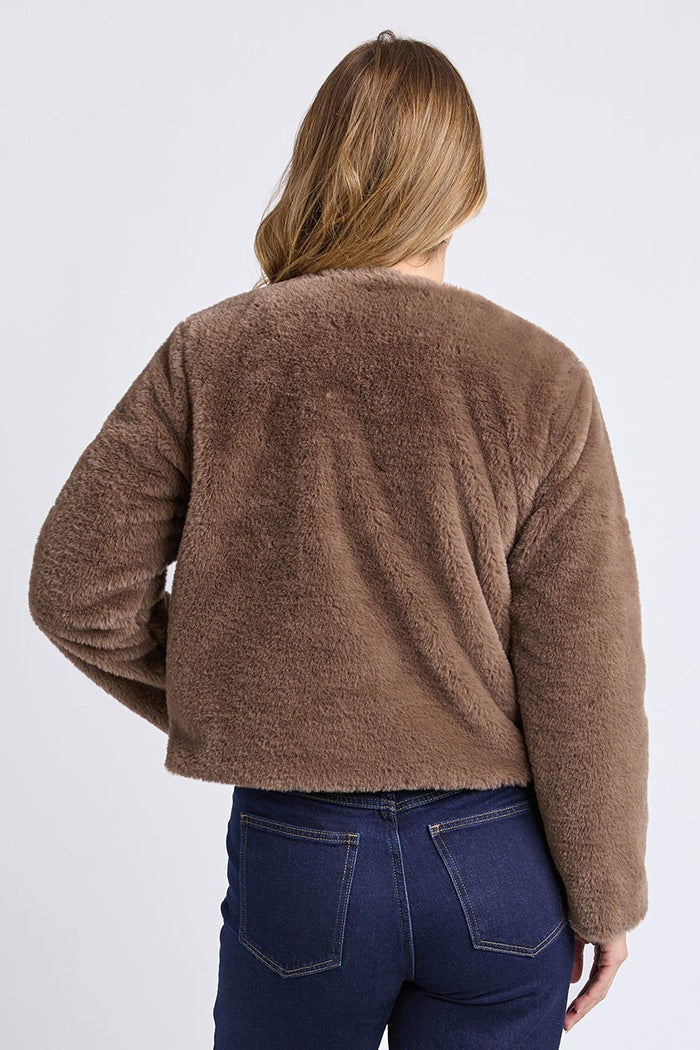 Person wearing a brown sweater and blue jeans on a white background
col_pattern