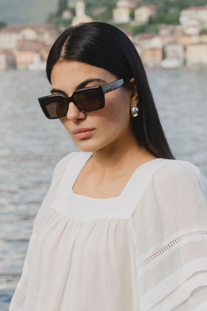model wearing tort square sunglasses