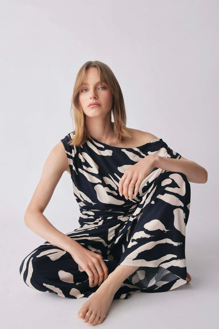 Model wears a one shoulder black and white pattern top