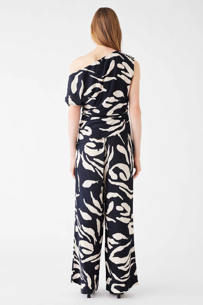 Model wears a one shoulder black and white pattern top