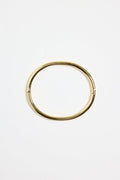 minimalist gold-plated bangle with polished finish and subtle clasp, photographed flat on a white background