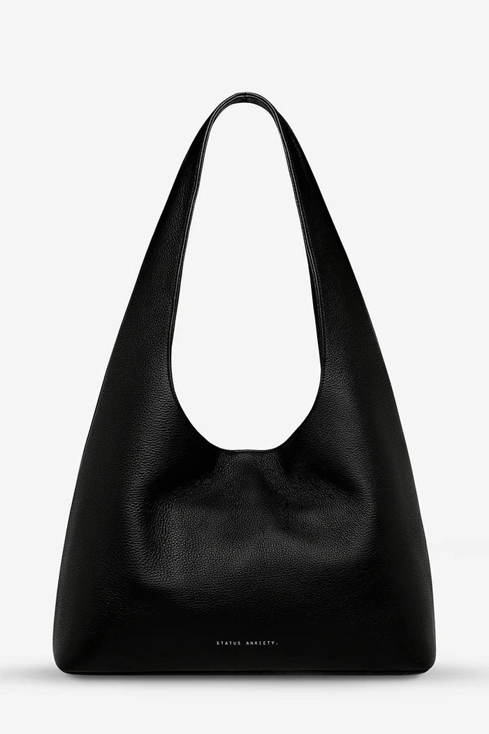 Black leather handbag on a light gray background