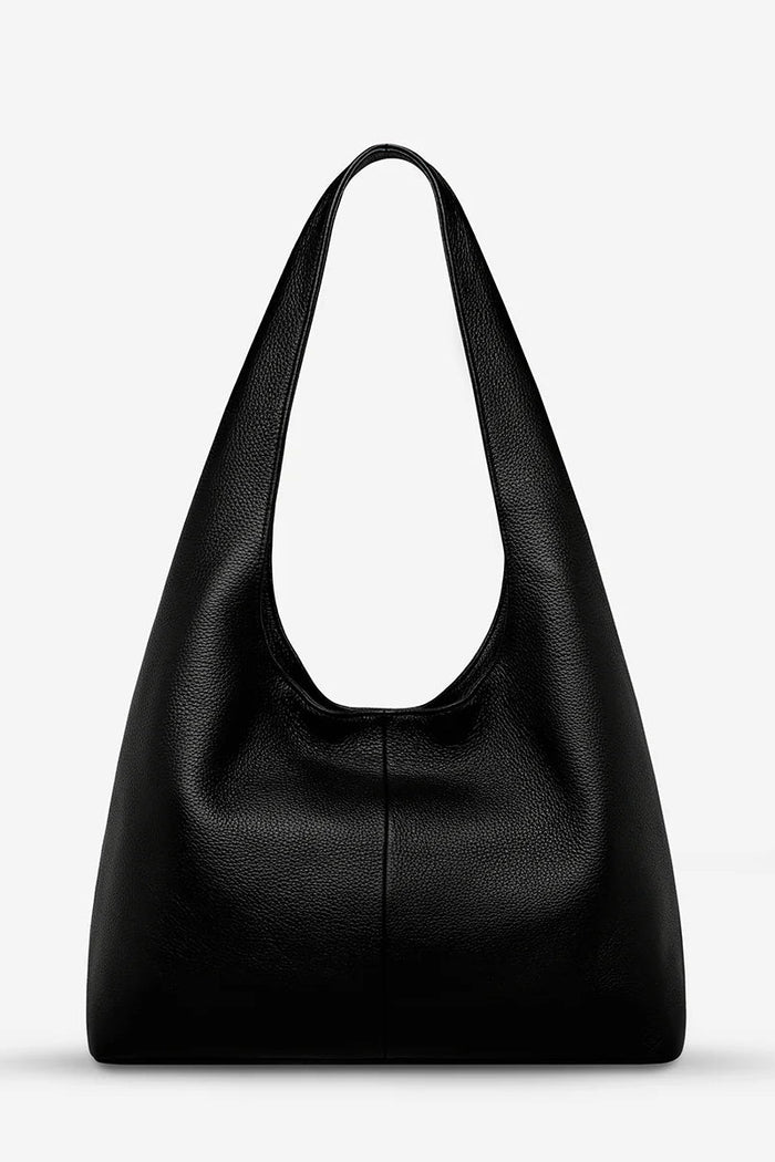 Black leather handbag on a light gray background