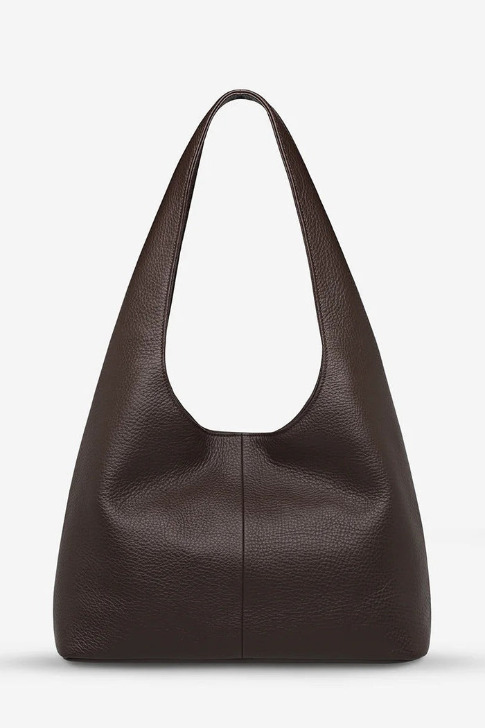 Brown leather handbag on a light gray background