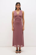 Woman wearing a pink polka dot dress on a white background
