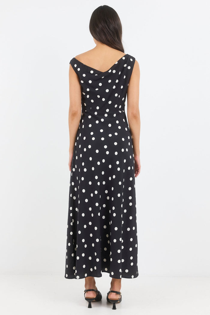 Woman wearing a black dress with white polka dots on a white background