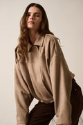 Woman wearing a beige shirt against a plain background