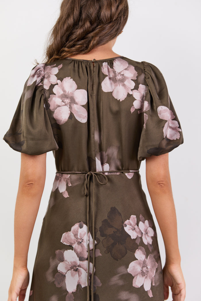 Woman wearing a floral dress with a plain background