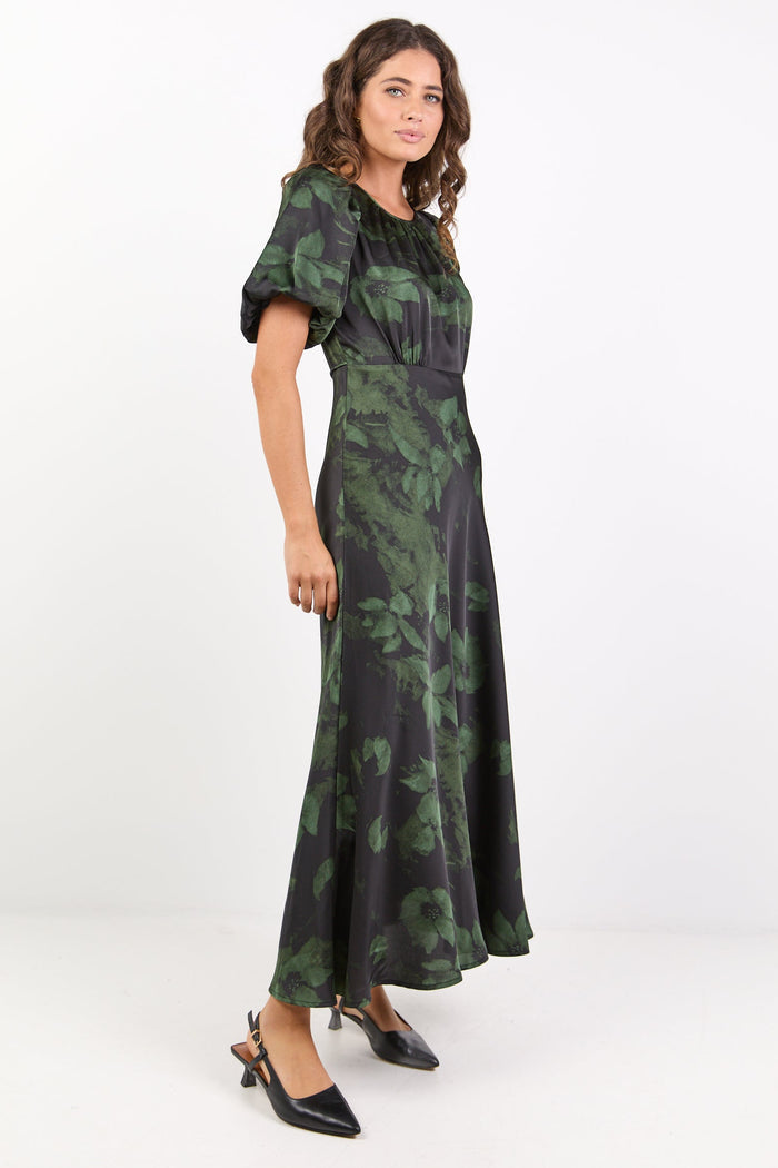 Woman wearing a green floral dress on a white background